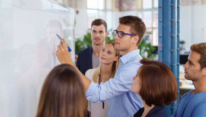 Mitarbeiter vor einem Whiteboard